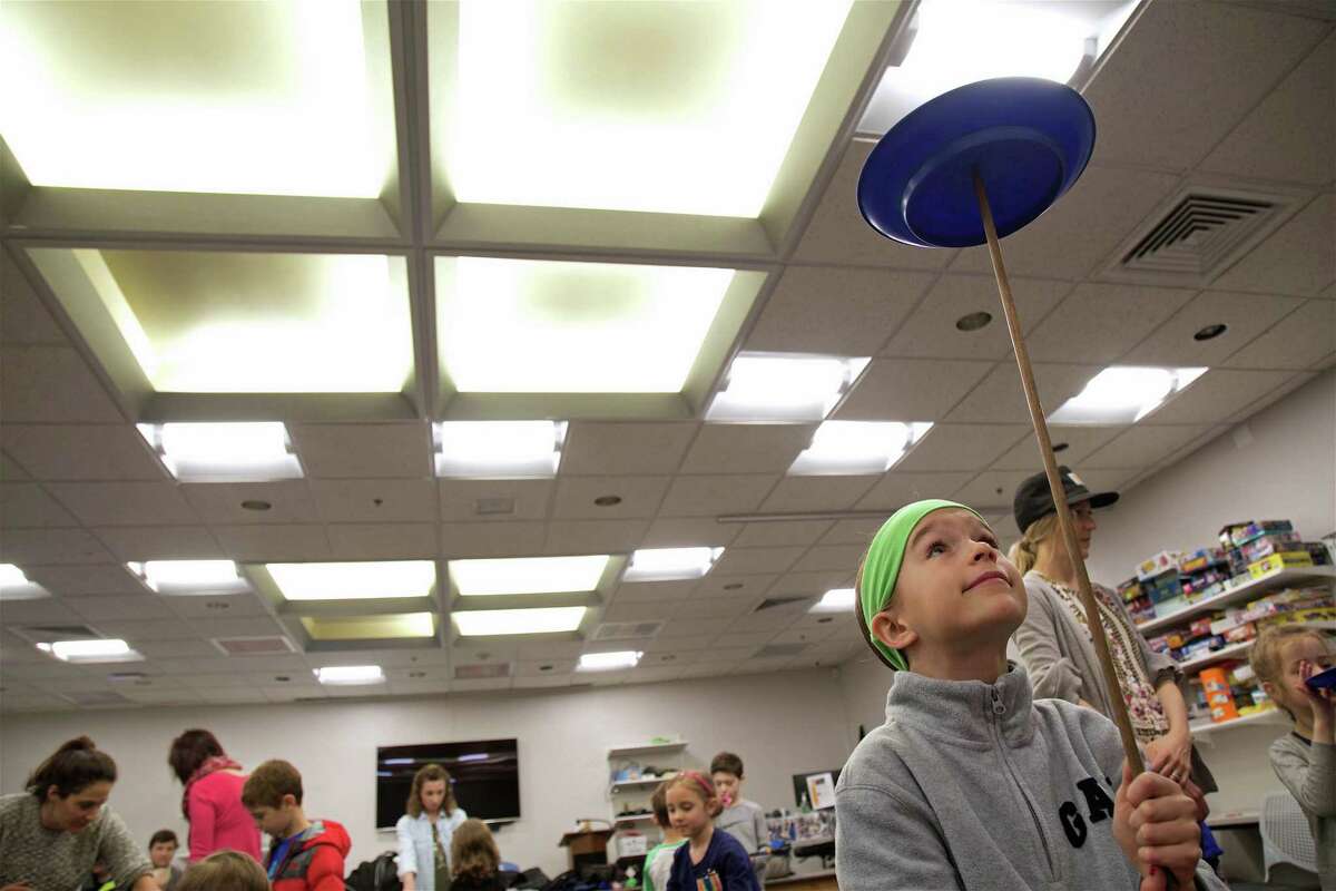 Juliet Olmstead, 8, of Fairfield, gets her plate moving at the circus arts demonstration at the Fairfield Woods Branch Library on Saturday, March 23, 2019, in Fairfield, Conn.