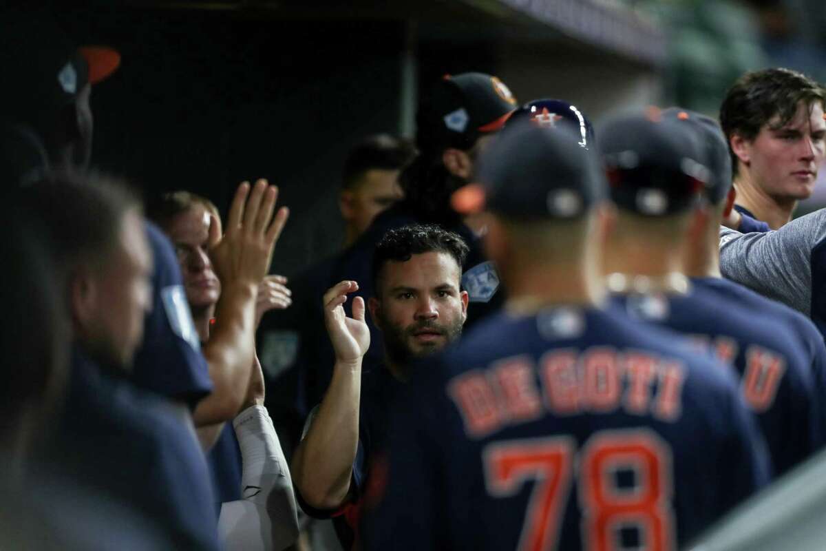 Houston Astros second baseman Jose Altuve (27) is congratulated by teammates after scoring on a single by left fielder Michael Brantley (23) during the third inning of a spring training game at Minute Maid Park on Monday, March 25, 2019, in Houston.