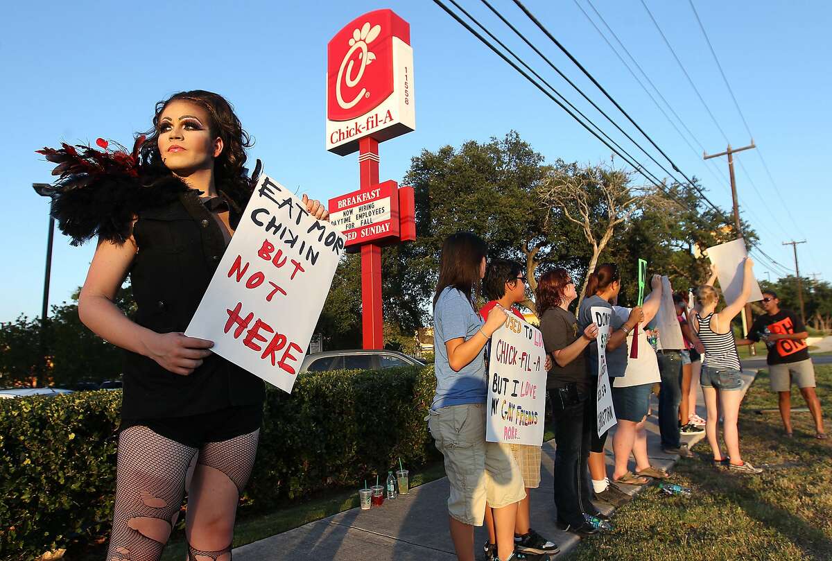 Sal Lupito (left) join other pro-same sex activists and supporters in a demonstration in front of the Chick-fil-A restaurant on Bandera Road and Loop 1604 on Friday, August 3, 2012. About 20 demonstrators showed up with signs as part of a nationwide protest as a reaction to recent statements made by Chick-fil-A president Dan Cathy on marriage based on his Christian faith. The group of same-sex marriage supporters was significantly smaller than an earlier turnout of patrons which filled the restaurants in support of Cathy and his right to free speech.