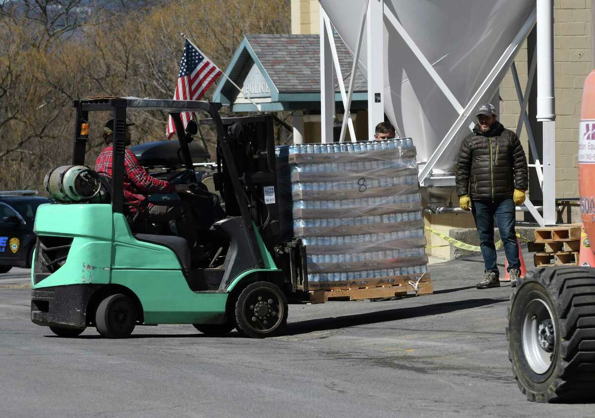 Cases of beer are taken out of the Commons Roots Brewing Company following a fire on Tuesday, March 26, 2019, on Saratoga Avenue in South Glens Falls, N.Y. The fire started on Monday night. (Will Waldron/Times Union)