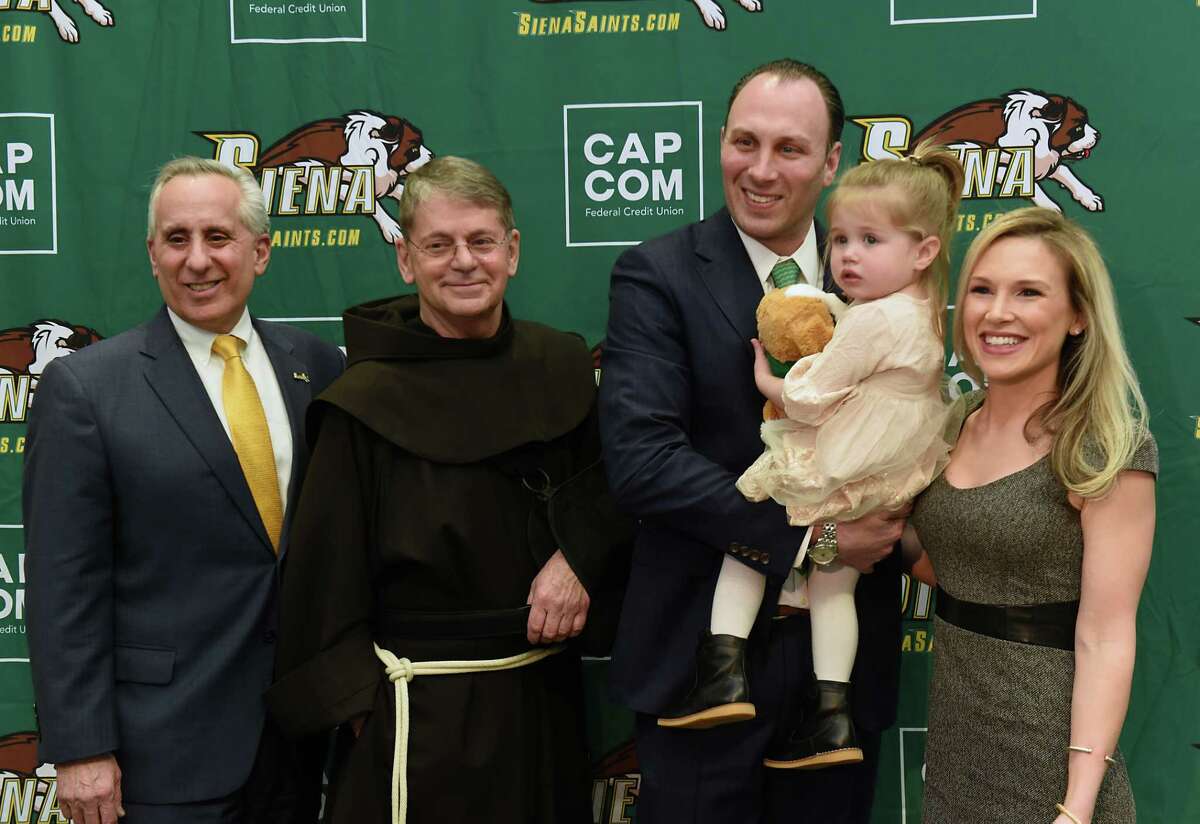 From left, Siena's Director of Athletics John D'Argenio, Br. F. Edward Coughlin, Carmen Maciariello and his daughter Reese, 2, and wife Laura pose for photos after Carmen was introduced as Siena's new head coach for their basketball team at the Times Union Center atrium on Tuesday, March 26, 2019 in Albany, N.Y. (Lori Van Buren/Times Union)