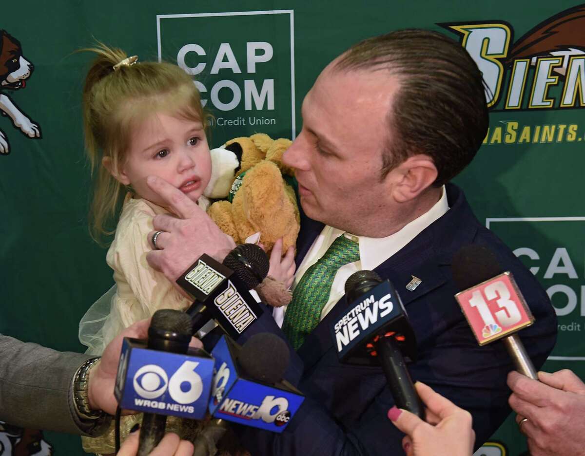 Carmen Maciariello wipes a tear from his 2-yr-old daughter Reese while speaking to the press after being introduced as Siena's new head coach for their basketball team at the Times Union Center atrium on Tuesday, March 26, 2019 in Albany, N.Y. (Lori Van Buren/Times Union)