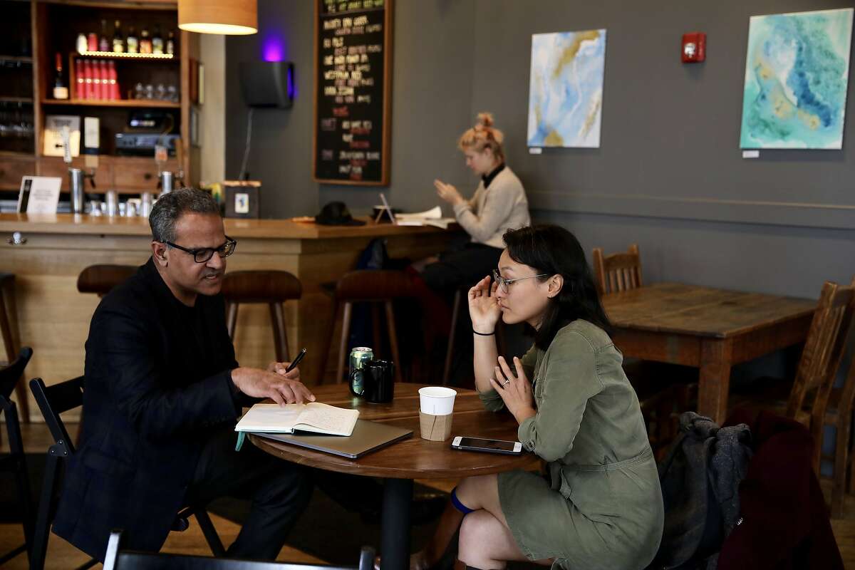 Suneel Ratan , 54, of Santa Cruz, and Hong Truong, 33, of San Francisco, have a meeting at Awaken Cafe as an earthquake alert test buzzes on mobile phones in Oakland, Calif., on Wednesday, March 27, 2019. The U.S. Geological Survey and the California Office of Emergency Services broadcasted alerts over a 60-square-block area of downtown Oakland.
