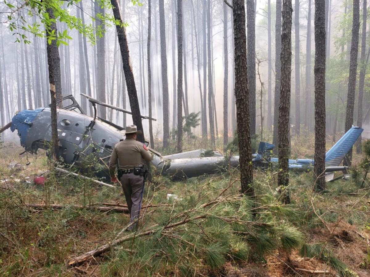 A trooper with the Texas Department of Public Safety investigates a deadly helicopter crash in northwest Montgomery County on Wednesday, March 27, 2019.