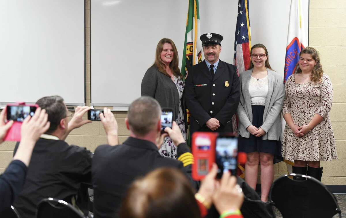 Greenwich Firefighter Bob Roth poses with his wife, Tammy, left, and daughters Sydney, second from right, and Madie, far right, after being sworn in to his new position as Fire Inspector at the Public Safety Complex in Greenwich, Conn. Wednesday, March 27, 2019. Under the promotion, Roth will assume the duties of recently retired Greenwich Deputy Fire Marshal Rich Funck.
