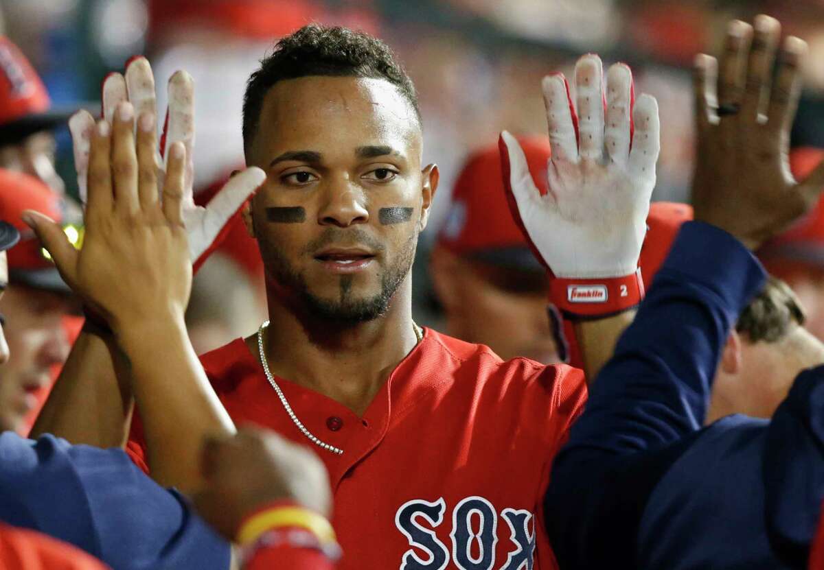 Boston Red Sox's Xander Bogaerts gets high-fives in the dugout after scoring during the seventh inning of the team's spring training baseball game against the Chicago Cubs on Monday, March 25, 2019, in Mesa, Ariz. (AP Photo/Sue Ogrocki)