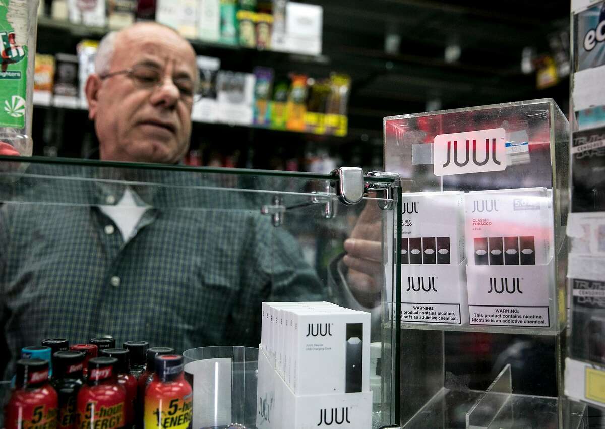 The Town Smoke Shop employee Walid Rahman shows a display case of Juul products in the Mission district of San Francisco, Calif. Thursday, March 21, 2019.