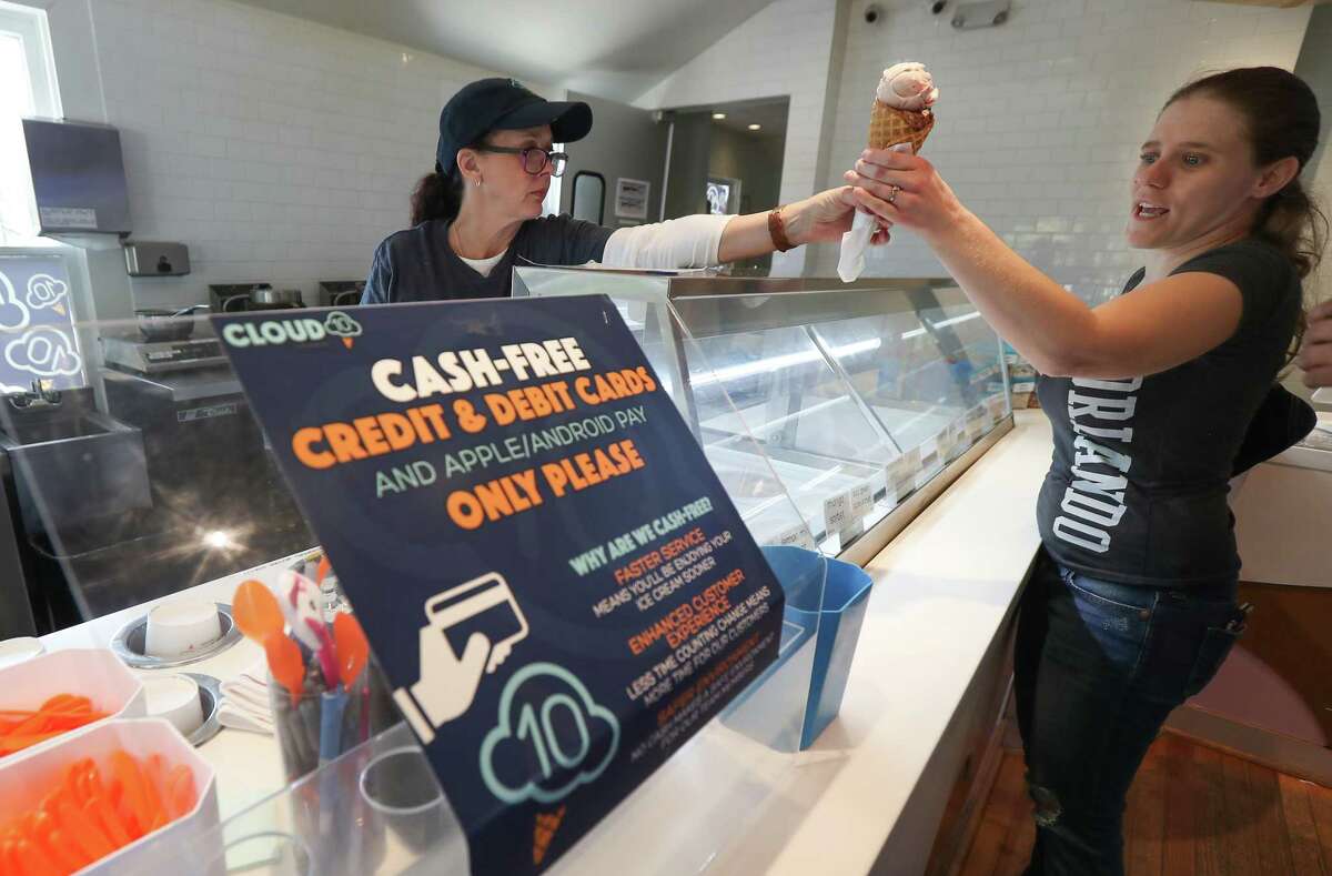 Cloud 10 Creamery employee Elysa King hands an ice cream cone to Angel Williams Wednesday, March 20, 2019, in Houston.