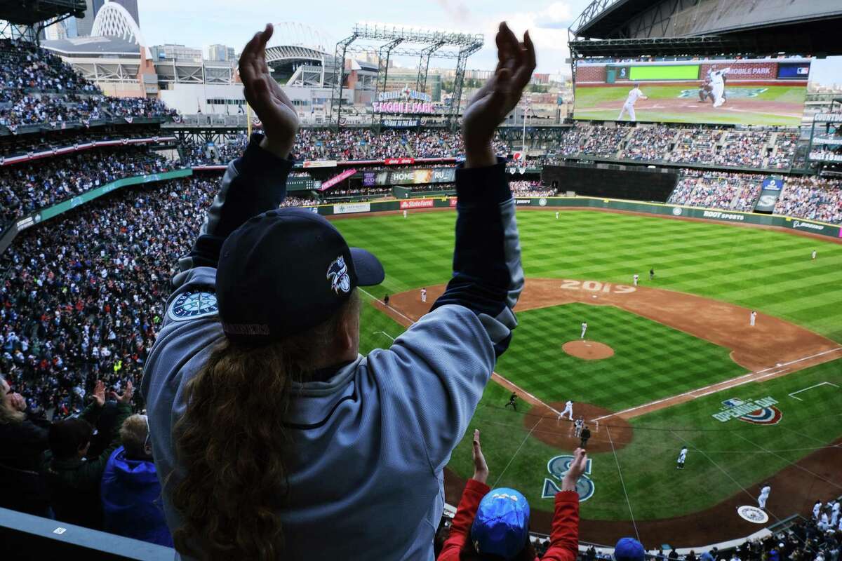 FILE -- Fans cheer as Mariner's Tim Beckham crosses home plate after hitting the first of his two homeruns and five team homeruns during the Seattle's home-opener against the Boston Red Sox at the newly renamed T-Mobile Park, Thursday, March, 28, 2019.