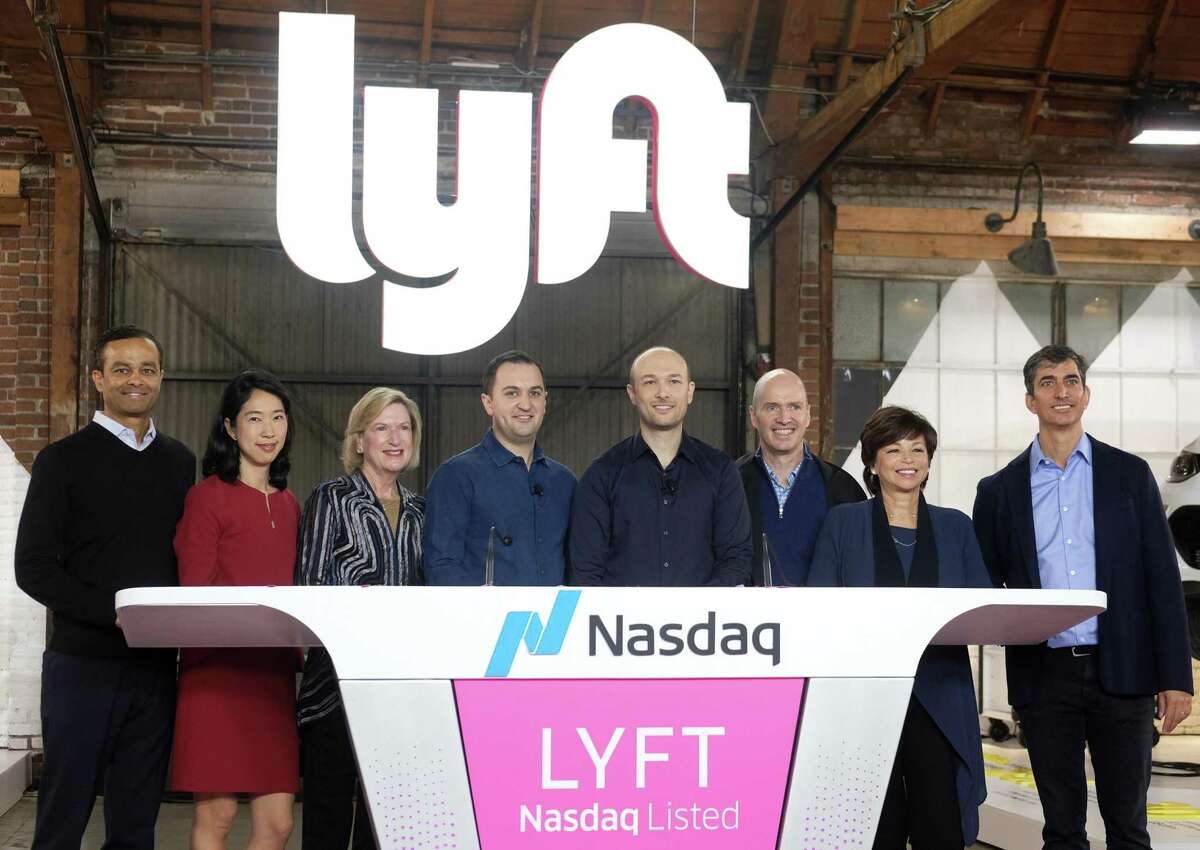 Lyft co-founder, John Zimmer, fourth from left, and Logan Green, fourth from right, pose with the Lyft Board of Directors after they rang a ceremonial opening bell in Los Angeles, Friday, March 29, 2019. On Friday the San Francisco company's stock will begin trading on the Nasdaq exchange under the ticker symbol "LYFT." (AP Photo/Ringo H.W. Chiu)