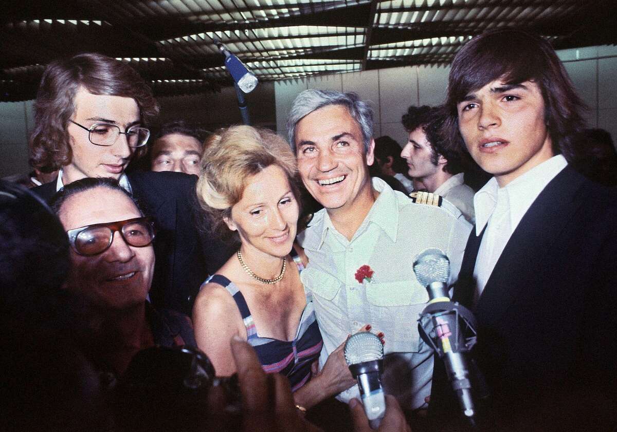(FILES) In this file photo taken on July 05, 1976, Air France captain Michel Bacos (C) is welcomed by his wife at Orly airport, outside Paris. - Michel Bacos, hailed as a hero for refusing to abandon his passengers when hijackers seized his plane in 1976, has died in Nice at the age of 95, his son told AFP on March 27, 2019. On June 27, 1976, Bacos was the captain of Air France Flight 139, carrying some 260 people from Tel Aviv to Paris. After a stop in Greece, four hijackers took control of the cockpit and forced Bacos at gunpoint to head for Benghazi, Libya, and then Entebbe, Uganda. (Photo by - / AFP)-/AFP/Getty Images