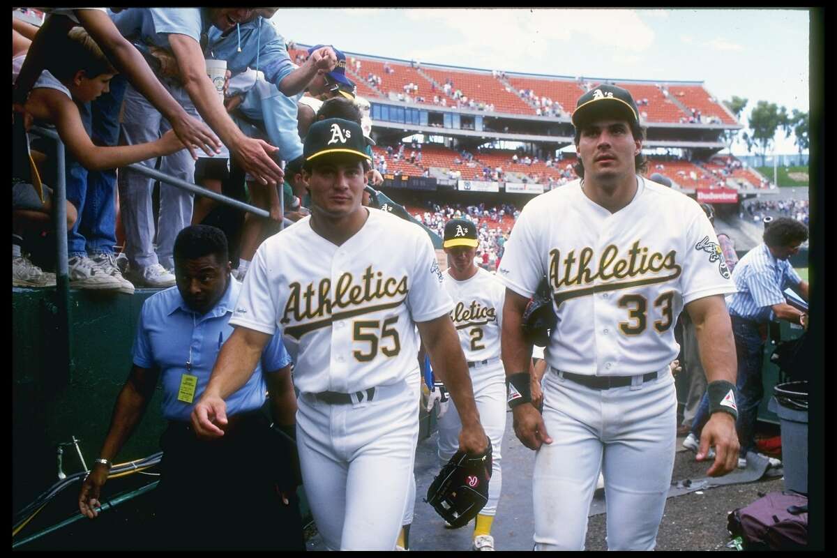 1990: Outfielder Jose Canseco of the Oakland Athletics (right) walks with his brother and teammate Ozzie Canseco. Mandatory Credit: Otto Greule /Allsport