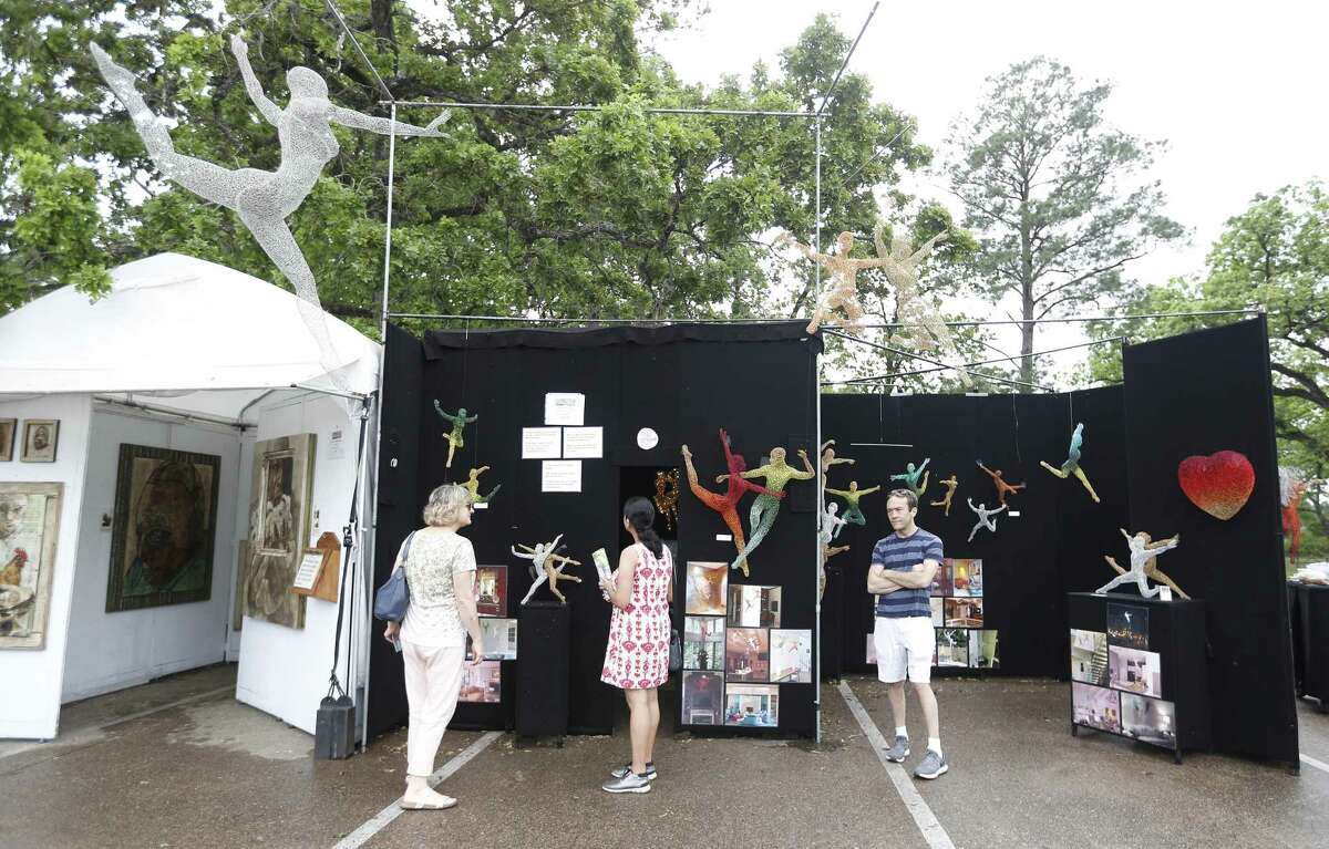 People check out sculture in Michael Gard's booth during the Bayou City Art Festival in Memorial Park, Saturday, March 30, 2019, in Houston. In it's 48th year, there are more than 300 artists showcasing their work, and as one of the nation’s premier outdoor fine art events, the three-day festival ends Sunday, and will be open from 10am-6pm. The festival benefits local nonprofit partners and features live music, local food vendors and food trucks, beverages, entertainment, a Children’s Creative Zone and more.