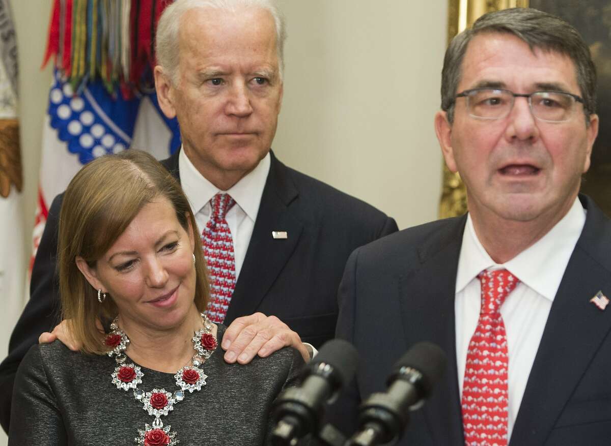 (FILES) In this file photo taken on February 17, 2015, Secretary of Defense Ashton Carter (R) speaks beside his wife Stephanie and US Vice President Joe Biden during a swearing-in ceremony in the Roosevelt Room of the White House in Washington, DC. - Joe Biden, who is leading polls for the Democratic presidential nomination, on Friday , March 29, 2019 faced a misconduct accusation by a Nevada ex-lawmaker claiming the then-vice president inappropriately kissed her before a campaign event. Lucy Flores, the state's Democratic nominee for lieutenant governor in 2014, said she was beside the stage awaiting her turn to address a rally when Biden put his hands on her shoulders from behind, then leaned in and smelled her hair. (Photo by Saul LOEB / AFP)SAUL LOEB/AFP/Getty Images