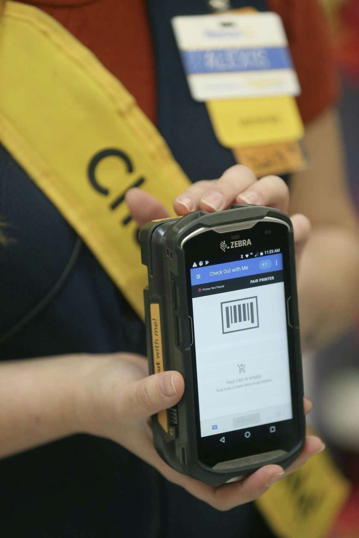 Alexis Byrd shows her hand-held check-out device Feb. 26, 2019 at the New Braunfels Walmart Supercenter that is used to check-out customers before they even get in line. The program that Walmart called "Check Out with Me" is one of the pieces of technology the company says it is using to improve shopping experiences in their stores.