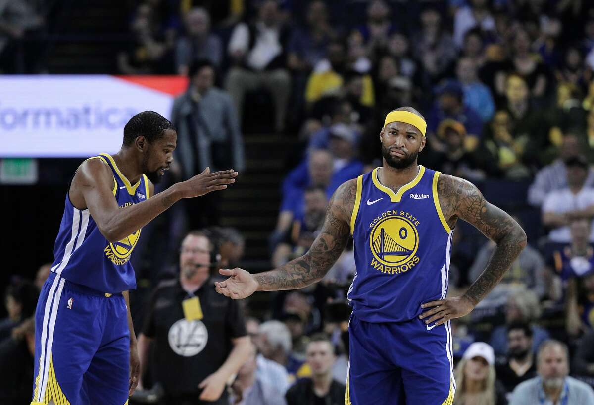 Kevin Durant (35) tries to console an upset DeMarcus Cousins (0) with a high five after Cousins was called for a foul in the first half as the Golden State Warriors played the Charlotte Hornets at Oracle Arena in Oakland, Calif., on Sunday, March 31, 2019.