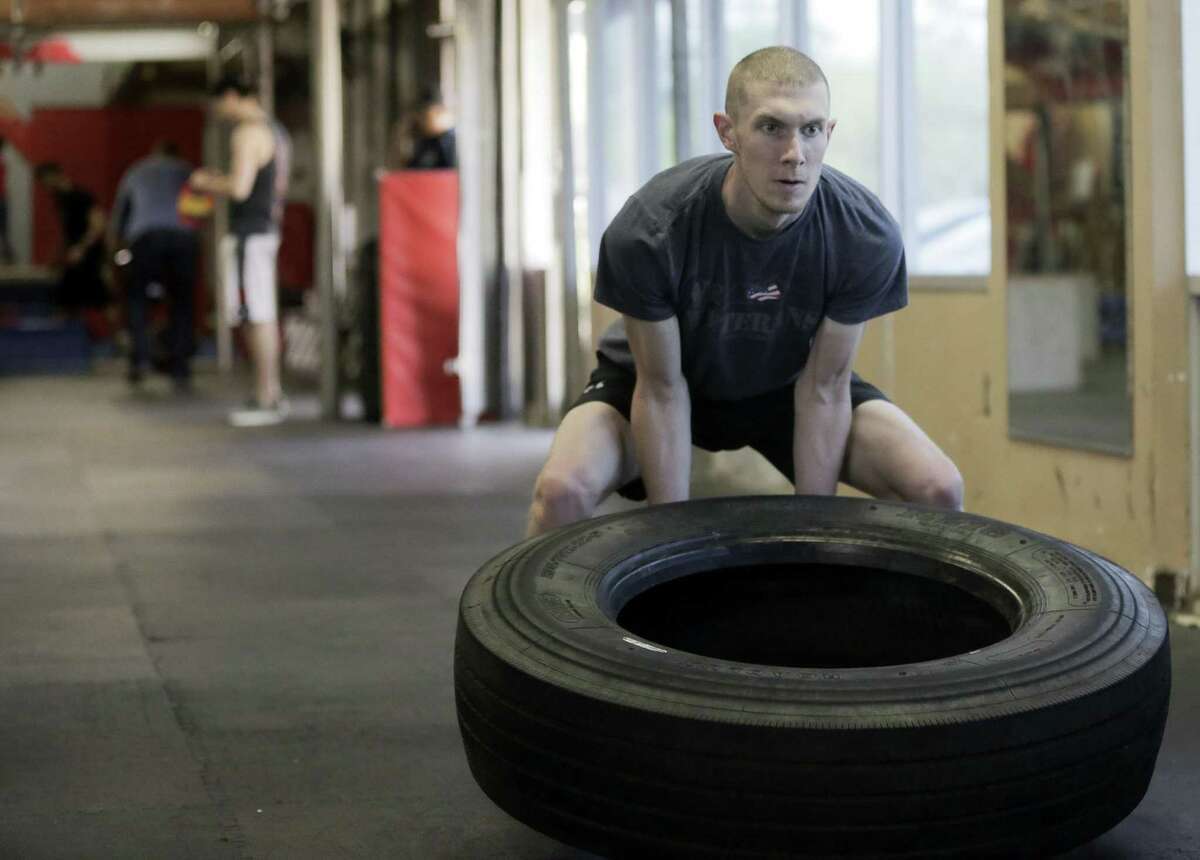 Andrew Millsap flips a tire during an American Ninja Training Course as part of signing up for apprenticeships through Adaptive Construction Solutions in Houston at Iron Sports Fitness on Thursday, March 14, 2019.
