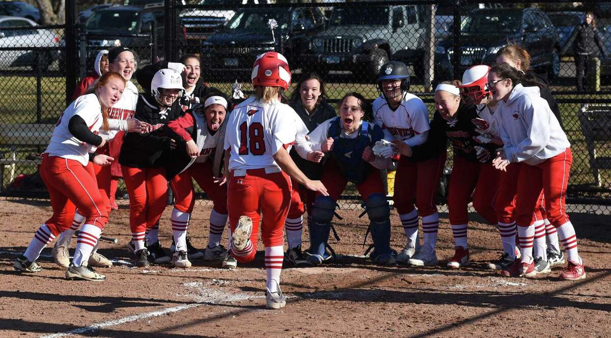 The Greenwich Cardinals await Charli Faugno (18) at the plate after Faugno hit a two-run home run in a 14-2 win over the New Canaan Rams in Waveny Park on Monday.