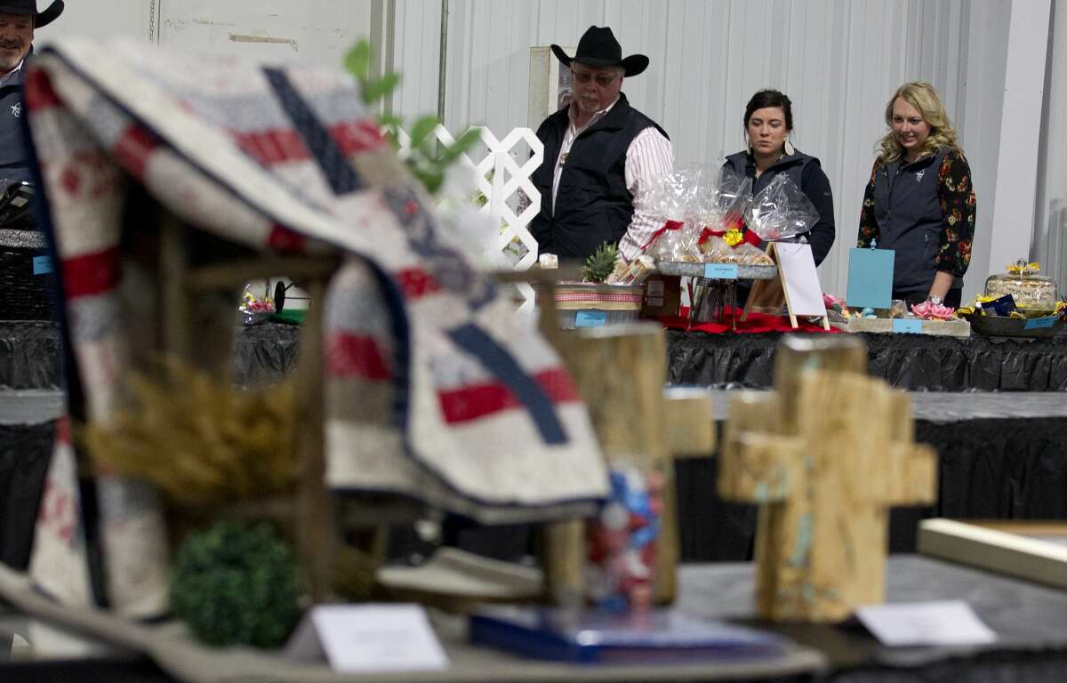 Onlookers view items before the non-livestock auction at the Montgomery County Fair and Rodeo, Monday, April 1, 2019, in Conroe.