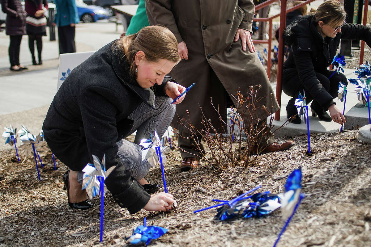 Atea Duso of Midland places a pinwheel in the ground during Safe and Sound Child Advocacy Center's annual pinwheel ceremony on Tuesday, April 2, 2019 in front of the Midland County Courthouse. (Katy Kildee/kkildee@mdn.net)