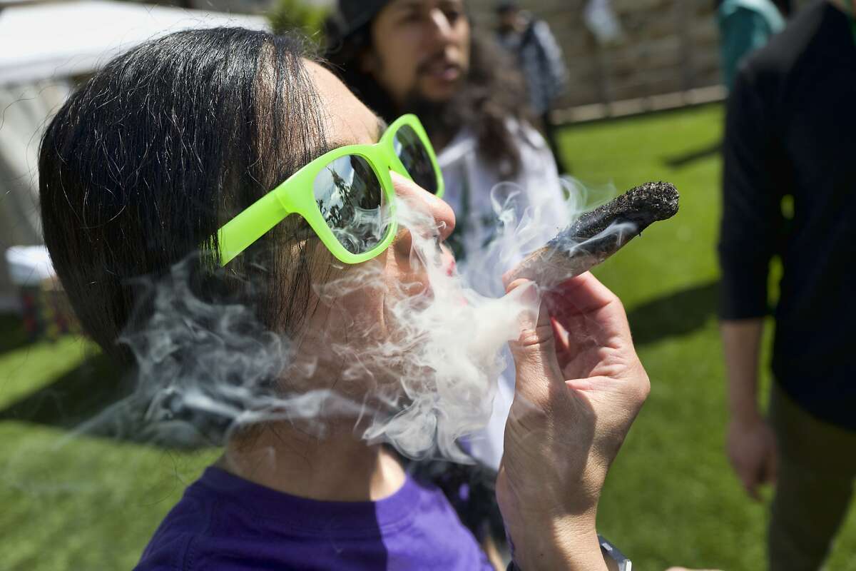 FILE - In this Friday, March 22, 2019 file photo, a participant takes a very smoky puff from a marijuana cigarette during at meet and greet at "Tommy Chong's Live, Love, and Smoke Tour hosted by GreenTours in the Woodland Hills section of Los Angeles. Los Angeles prosecutors are joining other California district attorneys to tap technology that could wipe out or reduce more than 50,000 old marijuana convictions. District Attorney Jackie Lacey announced Monday, April 1, 2019, that she is joining forces with a nonprofit organization that uses computer algorithms to identify eligible cases. San Francisco became the first city in the state to work with Code for America to expunge or reduce 8,000 convictions. (AP Photo/Richard Vogel, File)