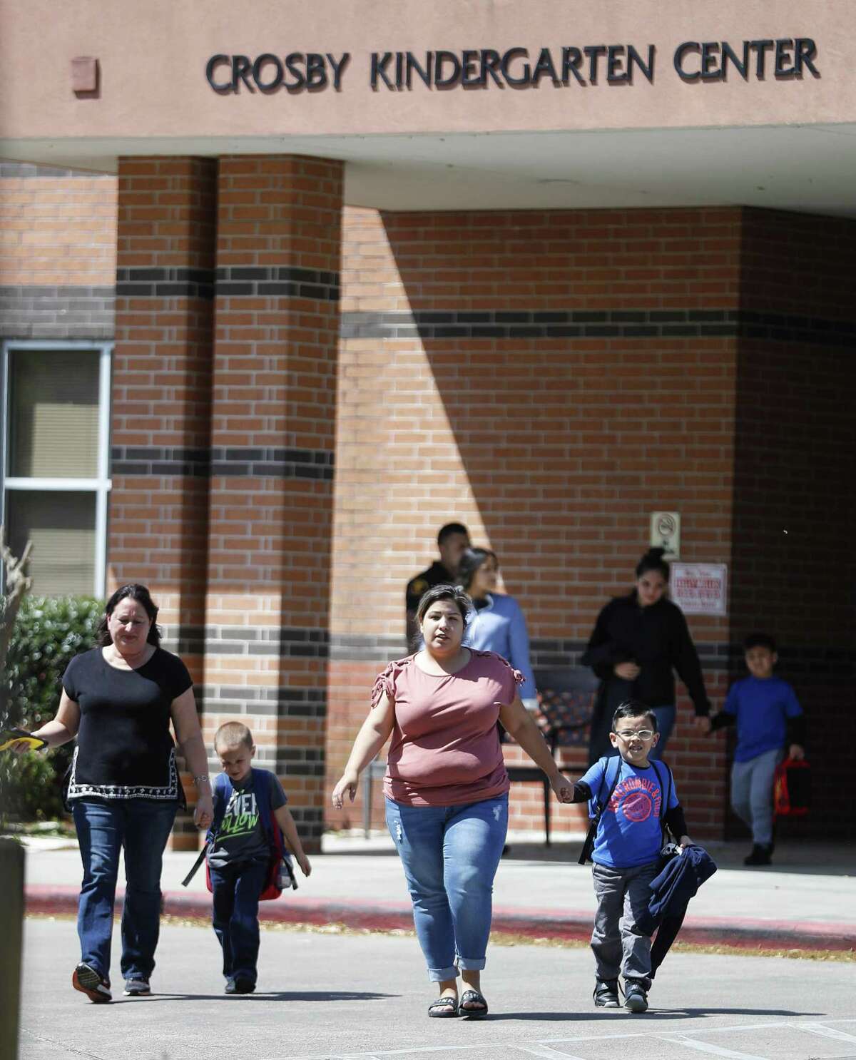 Parents pick up their children from the Crosby Kindergarten School as the plume from the KMCO fire, billowed in the backround, Tuesday, April 2, 2019, in Crosby.