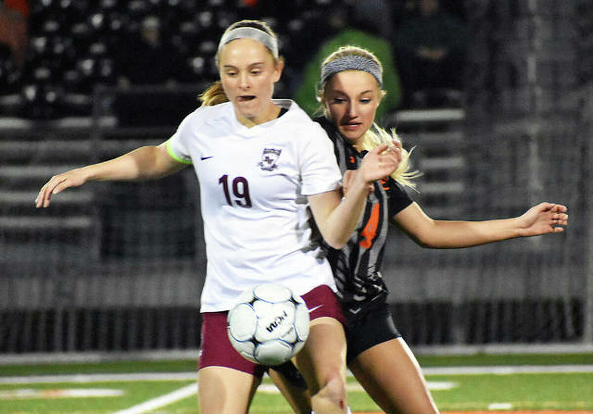 Edwardsville’s Emma Sitton, right, battles for a loose ball against a Belleville West player late in the second half.
