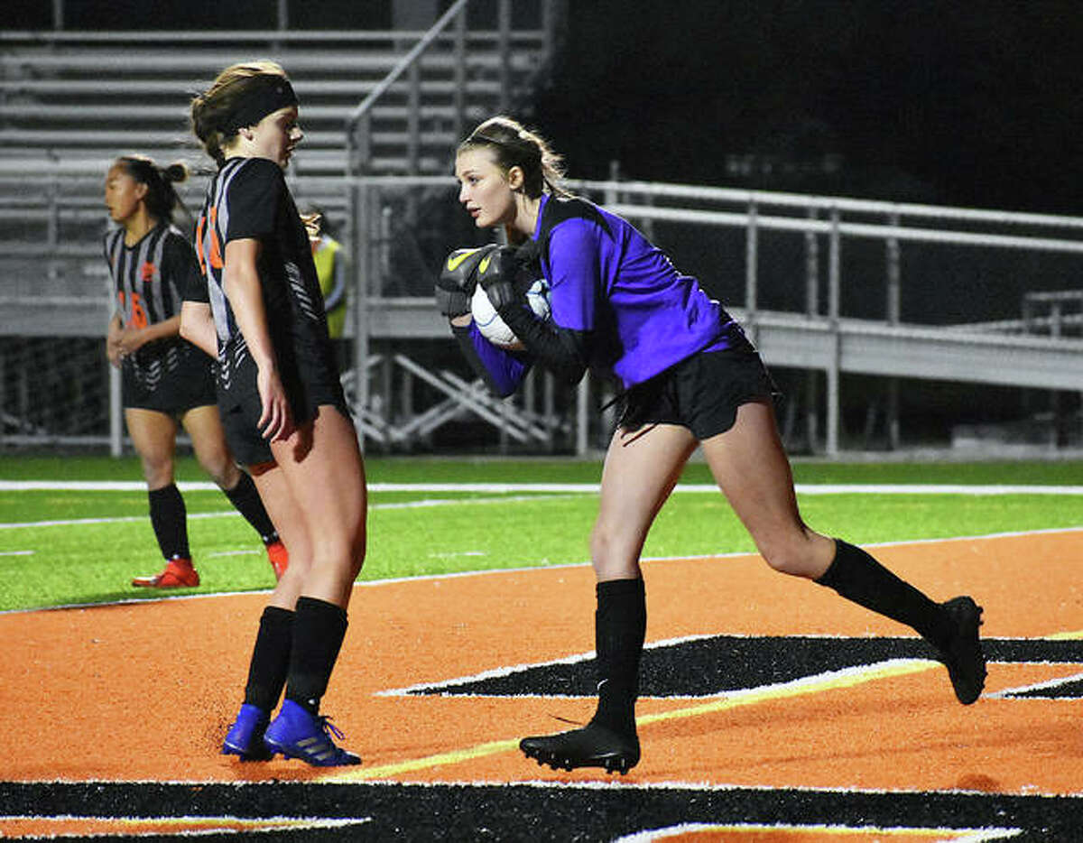 Edwardsville keeper Rachel Hensley scoops up a shot with defender Emma Hensley in on the play as well late in the second half.