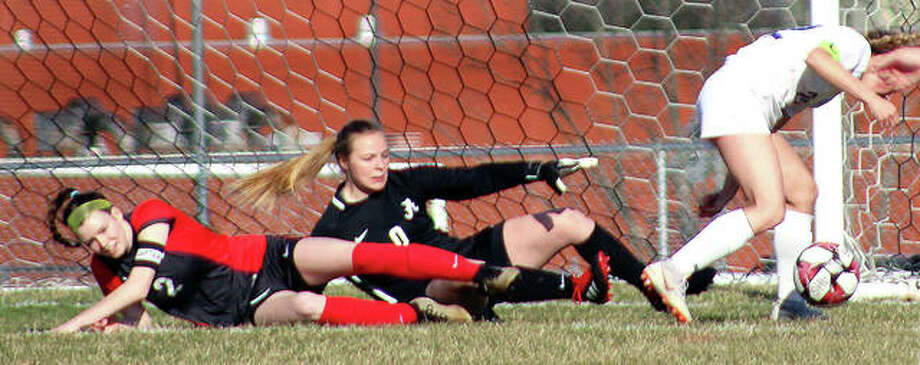 Alton’s Megan Zini, left, and goalie Addison Miller keep an eye on the ball from ground level as Colllinsville’s Mikaila Chrisman, right, tries to get around on it for a shot during Tuesday’s Southwestern Conference game at Alton High. The teams battled to a scoreless tie through regulation before Alton posted a 2-1 overtime victory. Photo: Pete Hayes | The Telegraph