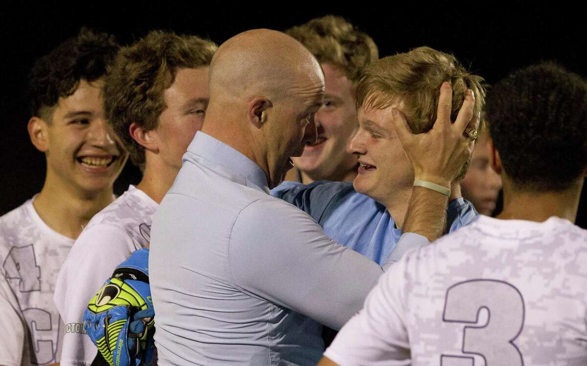 College Park head coach John Owens embraces goalie Ben Dixon after the team’s 1-0 win over Cypress Ranch during a Region II-6A area high school soccer playoff match at Magnolia High School, Tuesday, April 2, 2019, in Magnolia.