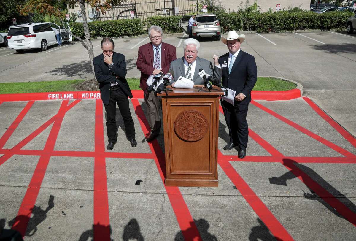 Stan Stanart, Harris County clerk, second from right, talks about voter registration problems during a press conference with Chris Daniel, Harris County district clerk, from right, Paul Bettencourt, state senator, and Orlando Sanchez, Harris County treasurer, in the parking lot of a UPS store, Tuesday, Oct. 30, 2018, in Houston. Bettencourt said 84 people are registered to vote at the UPS store through post office boxes.