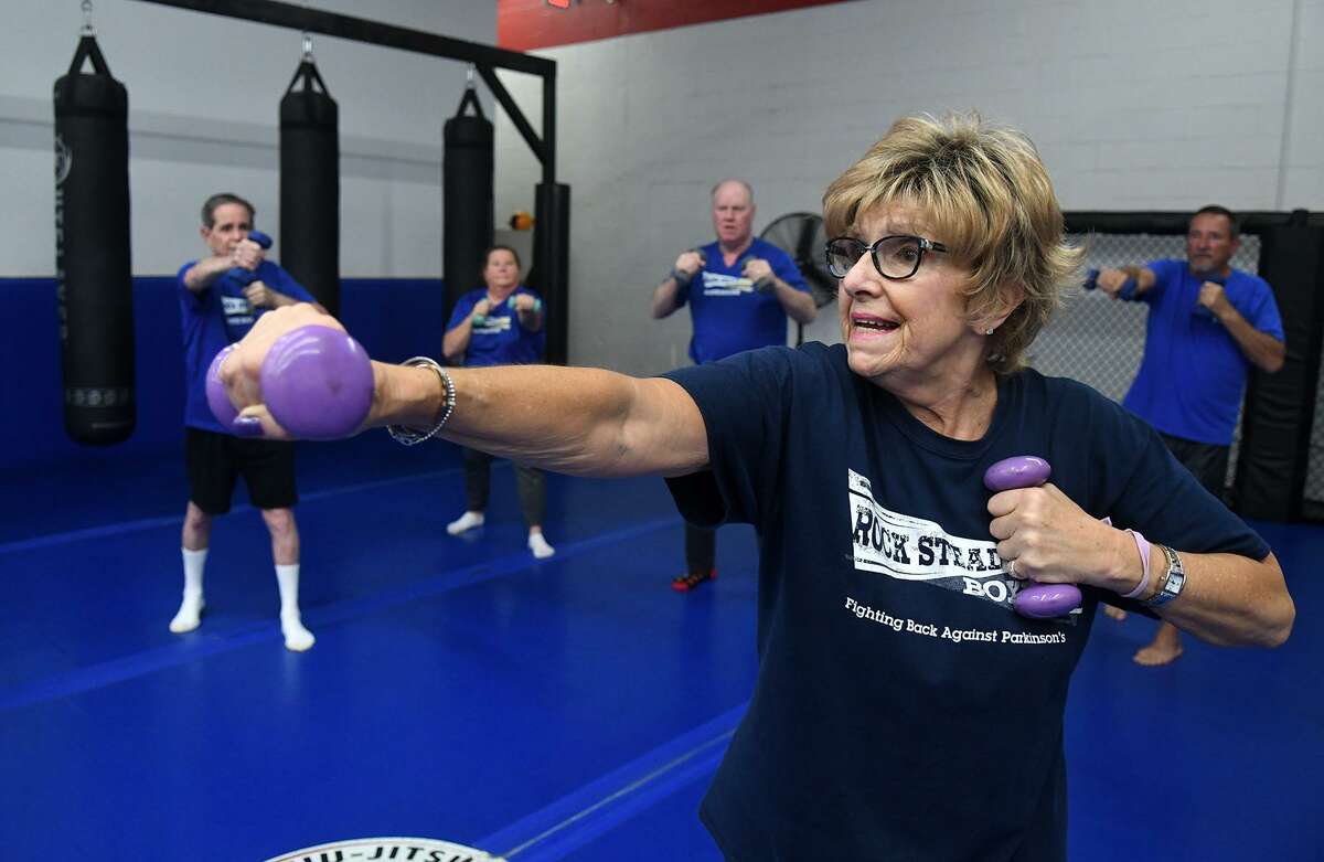 Coach Marilyn Renken leads her Rock Steady Boxing class in a boxing exercise with hand weights at Rock Steady Boxing North Houston on March 27, 2019.