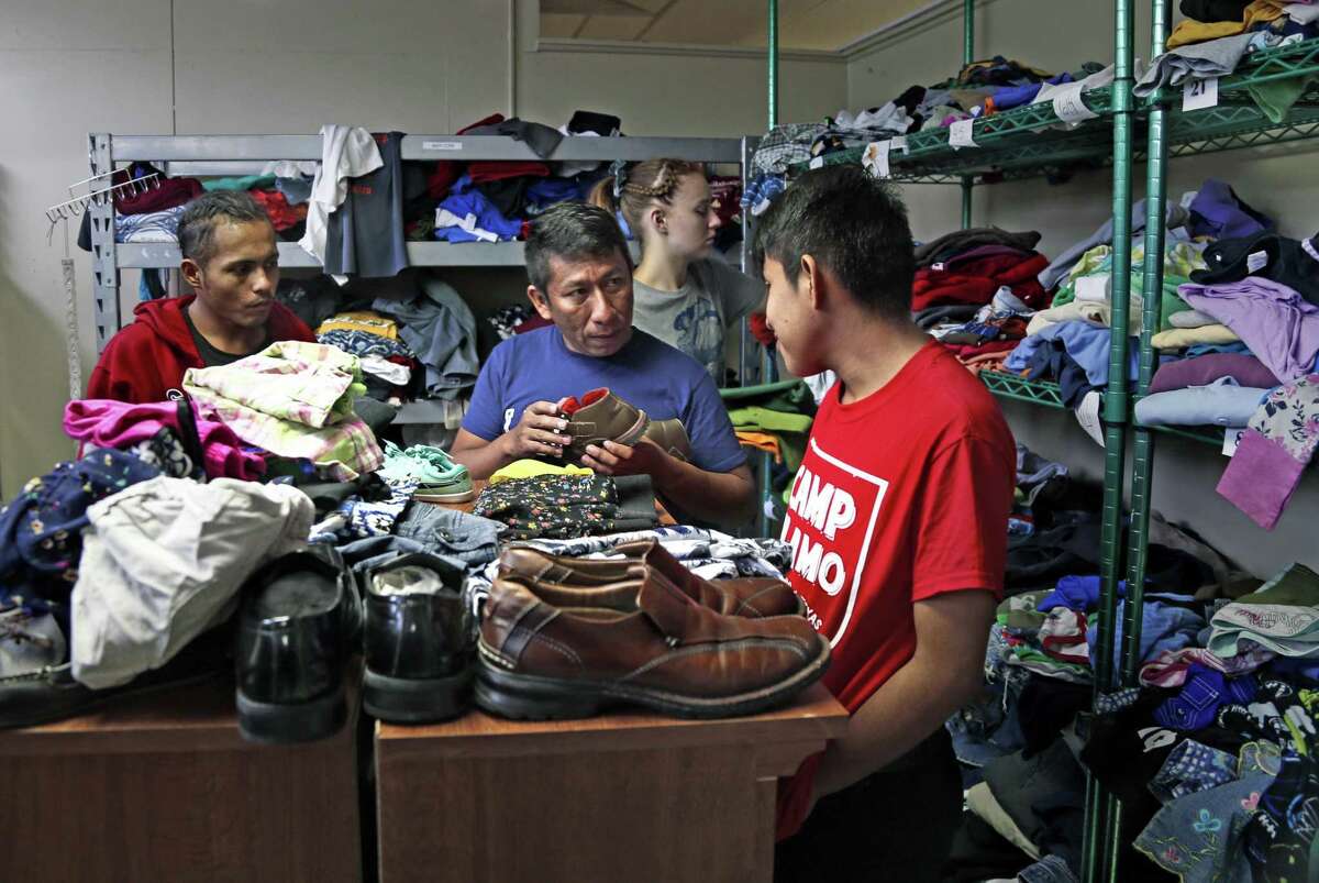 Recently released from border patrol custody, migrants look for clothes at the Guadalupe Community Center, provided by Catholic Charities who is helping to process the large increase in migrants being dropped off in San Antonio daily.