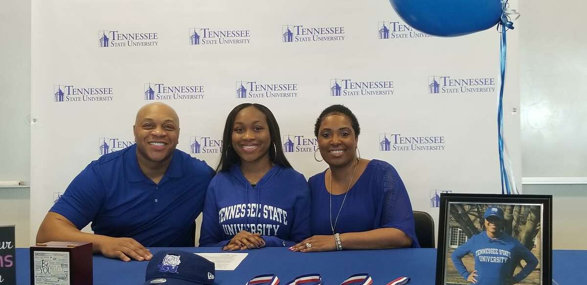 Hamden senior Tori Roberts, center, is flanked by her parents, Latef and Tushemia Roberts after signing to run track at Tennessee State.