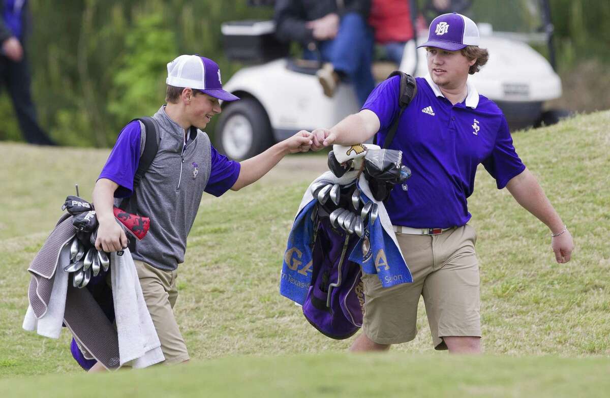Eyan Edsall of Montgomery, left, gives a fist bump to teammate Cade Walker during the final round of the District 20-5A championships on Wednesday, April 3, 2019, in Magnolia.