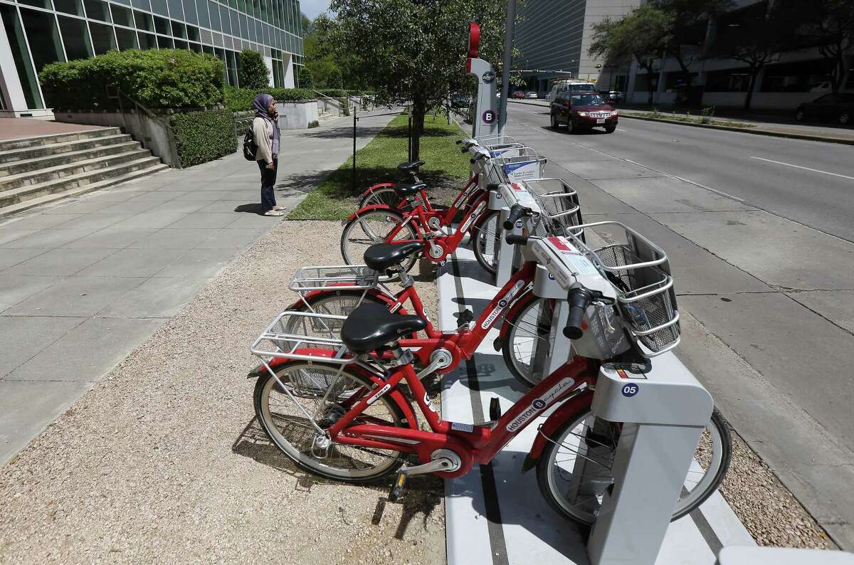 A woman makes a phone call before checking out a B-Cycle bike sharing system bike in the Texas Medical Center on April 2.