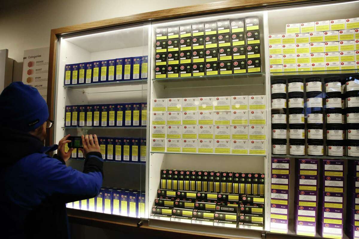 A customer takes a photo of cannabis products on display at the Fire & Flower cannabis shop in Ottawa, Ontario, Canada, on Monday, April 1, 2019. Canada's most populous province will finally open its first pot shops, nearly six months after legalization. Only 10 stores in Ontario had received the necessary licenses to open on April 1. Photographer: David Kawai/Bloomberg