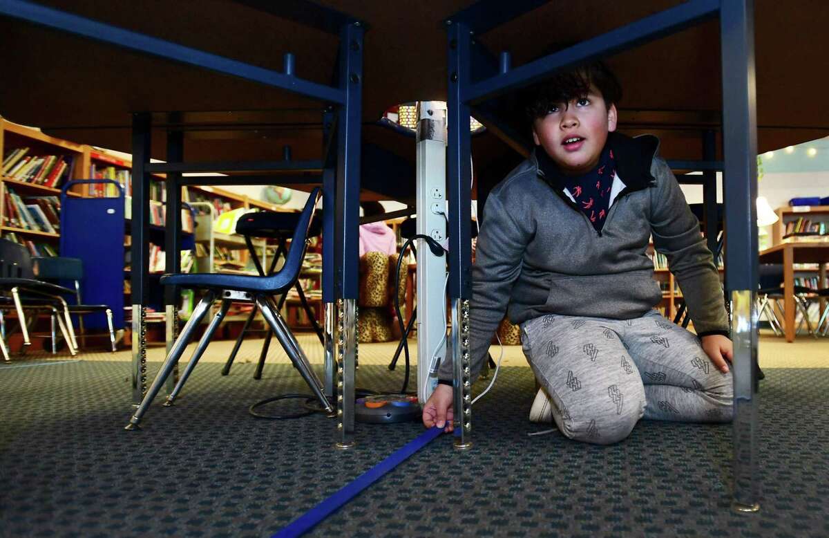 Students in Randall Austin's 5th grade Enhanced Curriculum class including Jeremy Puente runs tape under the tables before the class uses iPads to measure and create a design for renovation of the library Tuesday, March 19, 2019, at Kendall Elementary School in Norwalk, Conn. Kendall raised its state assessment score impressively in part with programs like the Enhanced Curriculum classes.