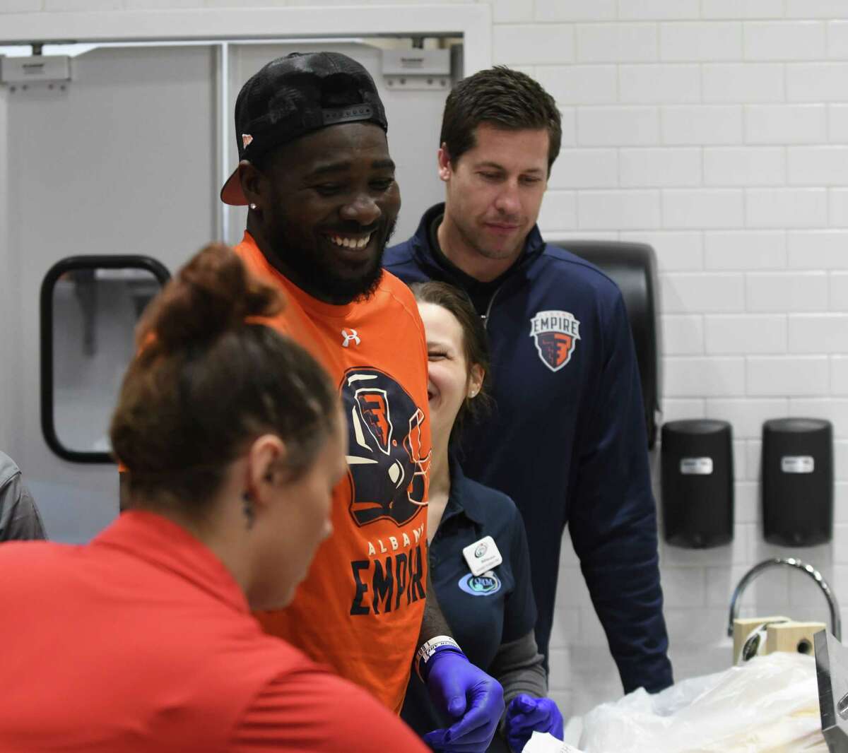 Albany Empire players Joe Sykes, center, and Tommy Grady, right, from the Albany Empire Arena Football League team, make sandwiches at the new Empire Deli at Albany International Airport on Friday, April 5, 2019, in Colonie, N.Y. The deli is located near the security gate on the unsecured side. It is branded in conjunction with the arena football team. (Will Waldron/Times Union)