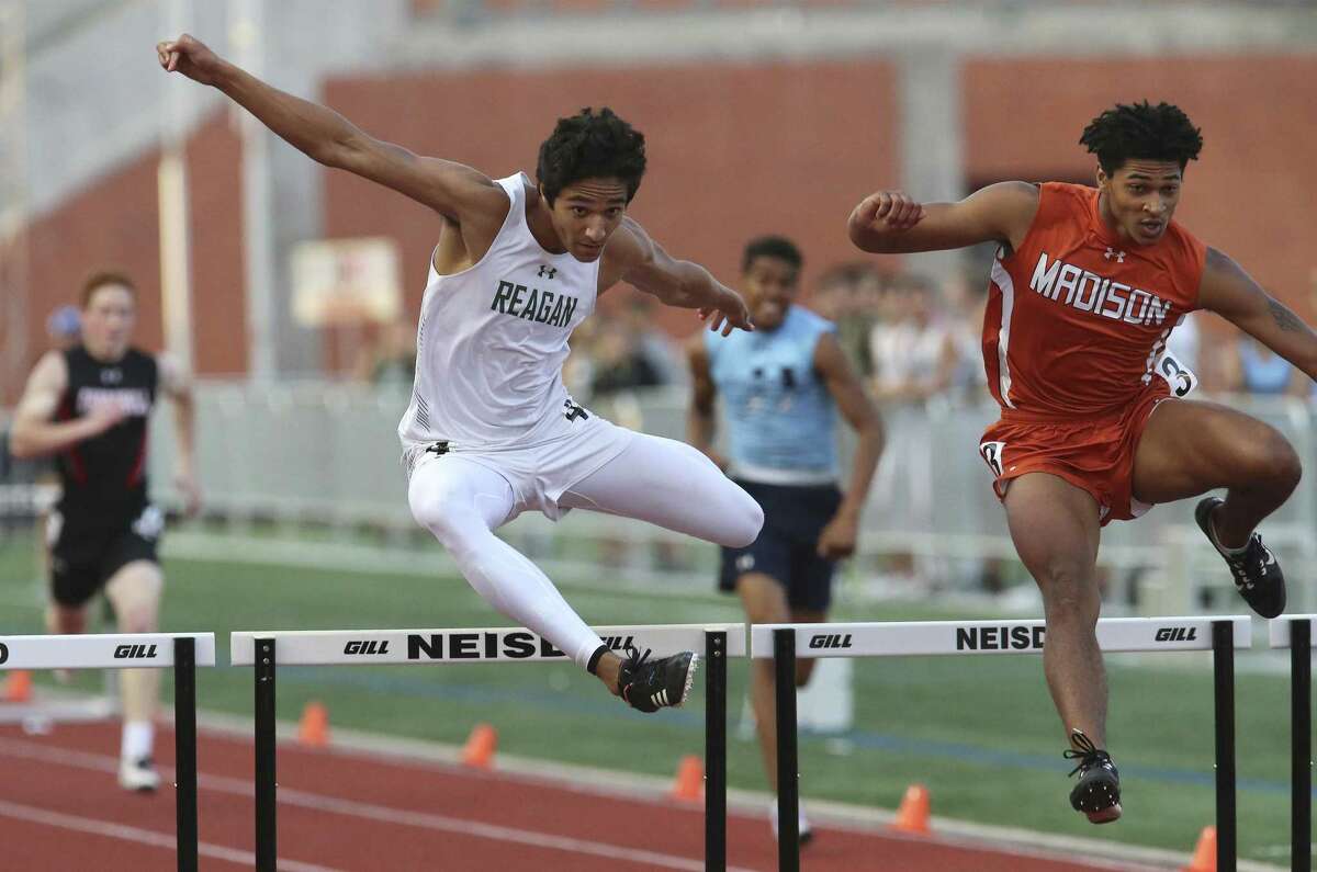 Reagan's Noah Crawford (left) and Madison's Dante Heaggans leap for the finish in the 300-meter hurdles at the District 27-6A track meet at Heroes Stadium on Friday, Apr. 5, 2019. (Kin Man Hui/San Antonio Express-News)