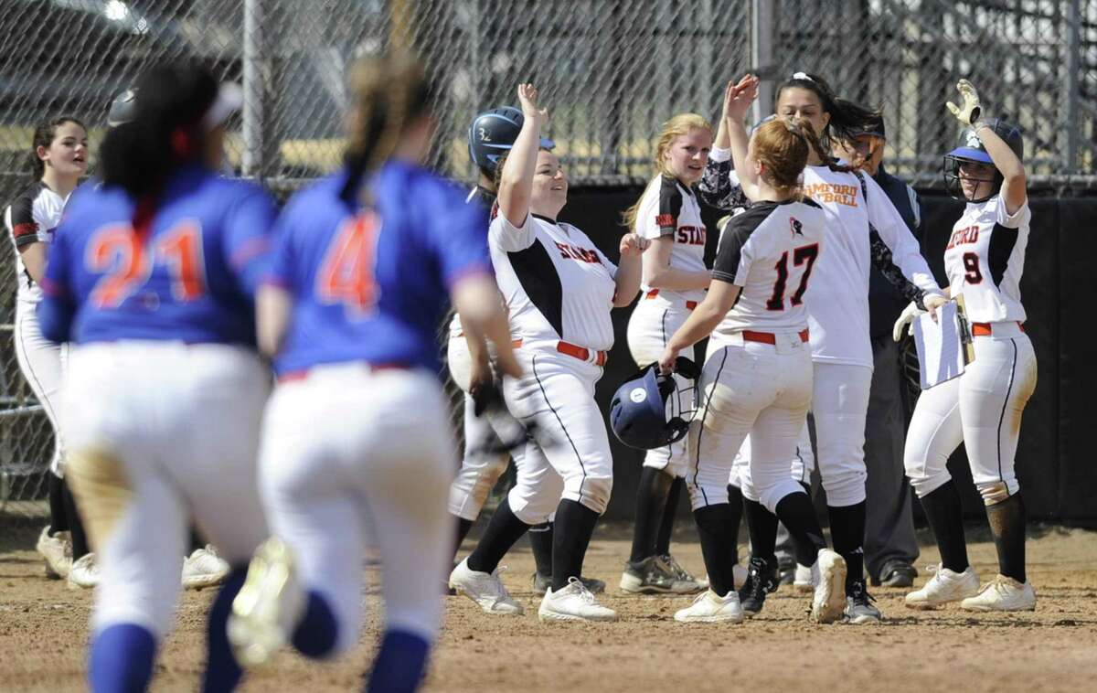 Stamford’s Diana Magarian (17) celebrates with her teammates after driving in the winning run with a single in the 10th inning of the Black Knight’s 7-6 victory over Danbury on Saturday in Stamford.