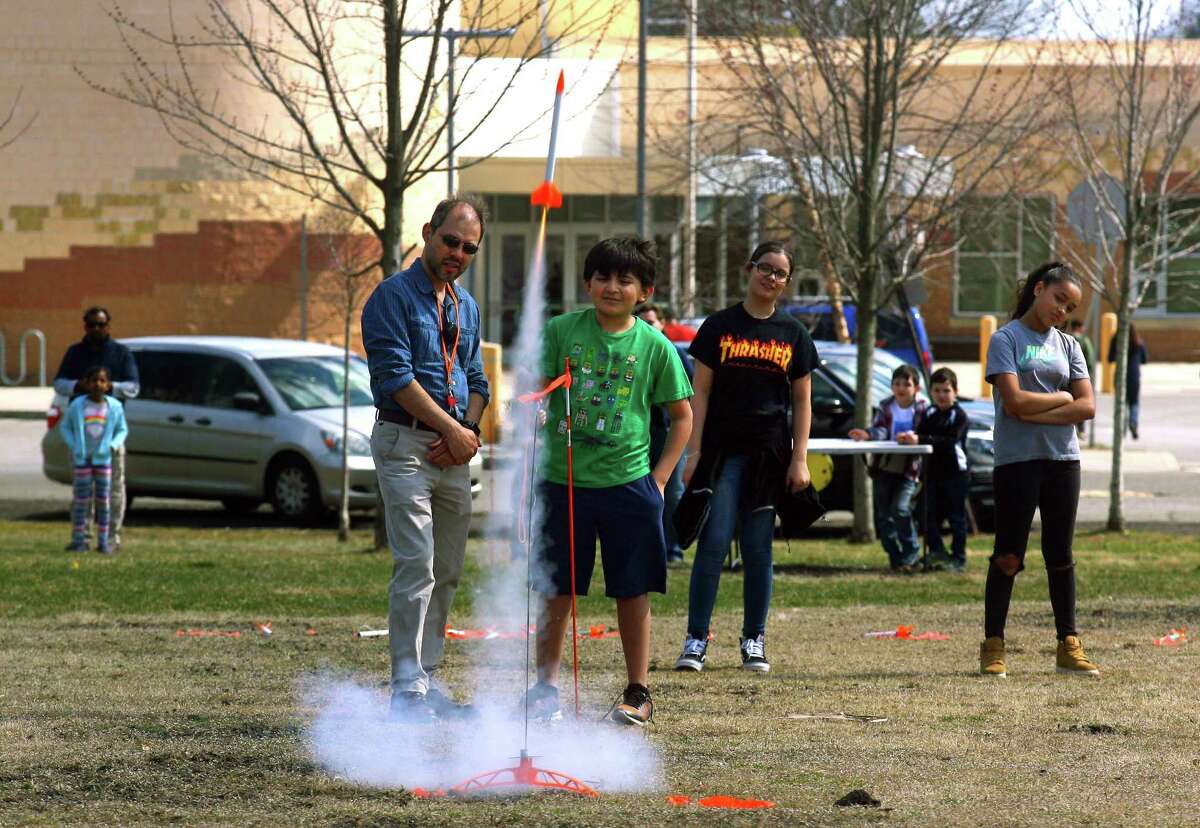 Instructor David Mestre and Jerson Bustillo, 10, watch as Jerson launches his rocket from Veterans Field during the Discovery Museum's annual Science Day in Bridgeport, Conn., on Saturday Apr. 6, 2019. As many as 1400 children got to take part in a variety of activities related to space research and exploration. Some of the highlights included a Live Science Demo, Astronaut Training, drone flights with Connecticut Wild Flyers and even a piece of moon rock on display. Science Day is made possible by a grant from the NASA Connecticut Space Grant Consortium.