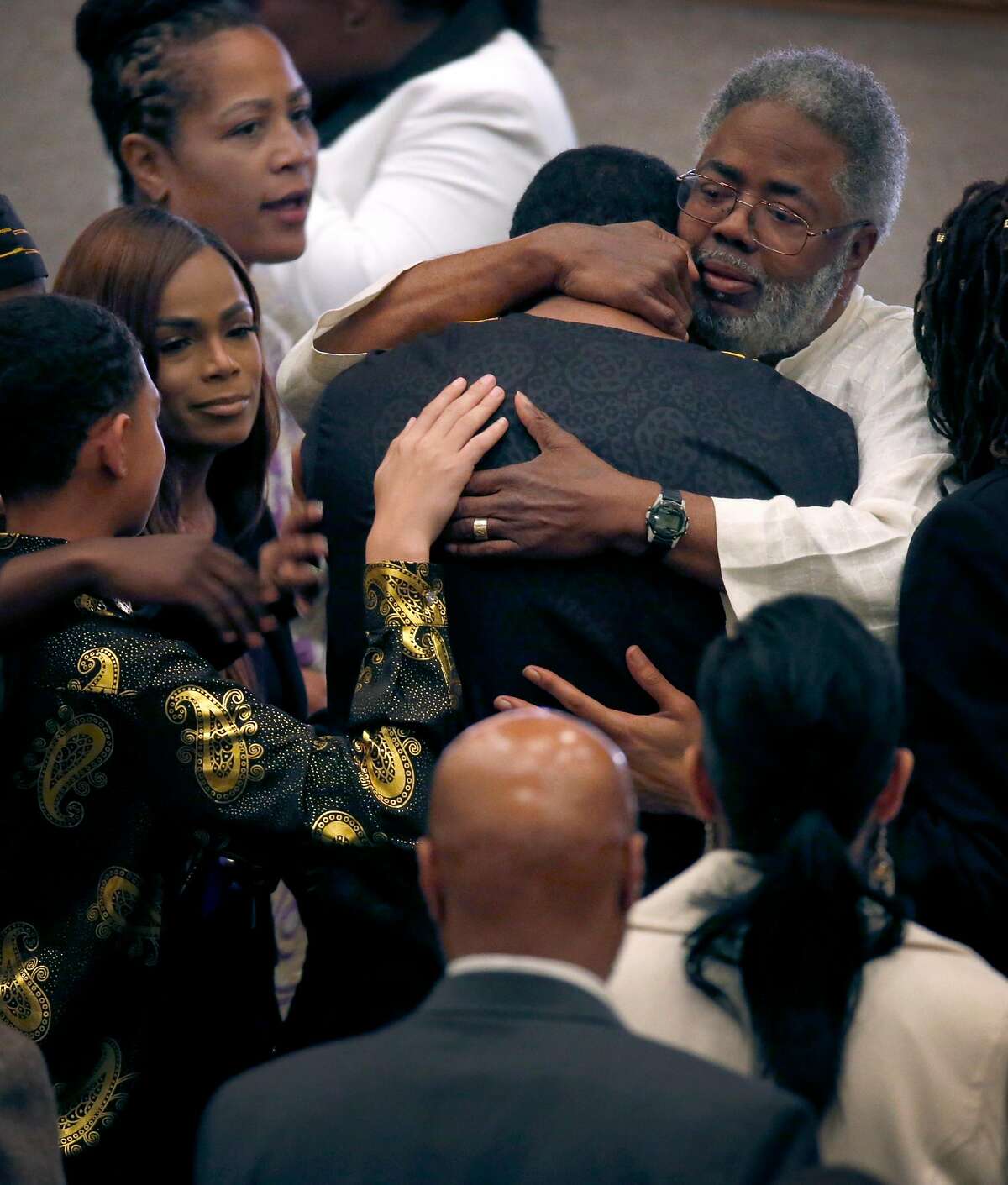 Oakland city council member Lynette Gibson McElhaney (top left) and her husband Clarence A. McElhaney Jr. (top right) console family friends at a memorial service and celebration of life for their son Victor McElhaney in Oakland, Calif. on Saturday, March 23, 2019. Victor McElhaney, 21, a music major at USC, was killed during a robbery in Los Angeles two weeks ago.