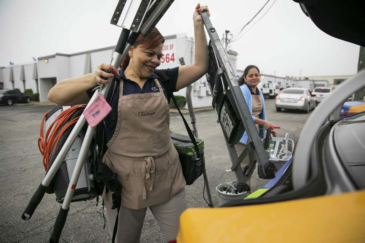 Adis Diaz loads cleaning supplies into a company car during morning deployment on Friday, April 5, 2019, at Maid Brigade, a residential cleaning service in Gulfton.