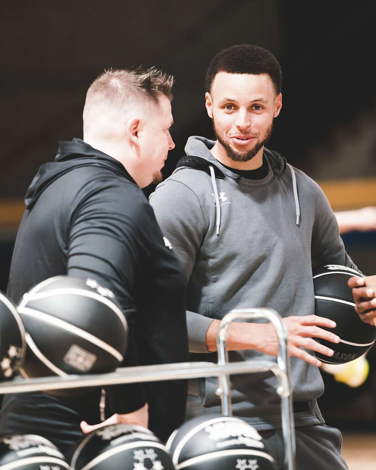 Stephen Curry and his personal skills development coach, Brandon Payne, huddle during the Underrated Tour's Oakland stop in April.