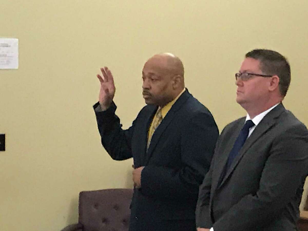 Retired Troy Detective Aaron Collington raises his hand as he  appears with his attorney Josepha Ahearn Monday April 8, 2019 to plead guilty in Rensselaer County Court.