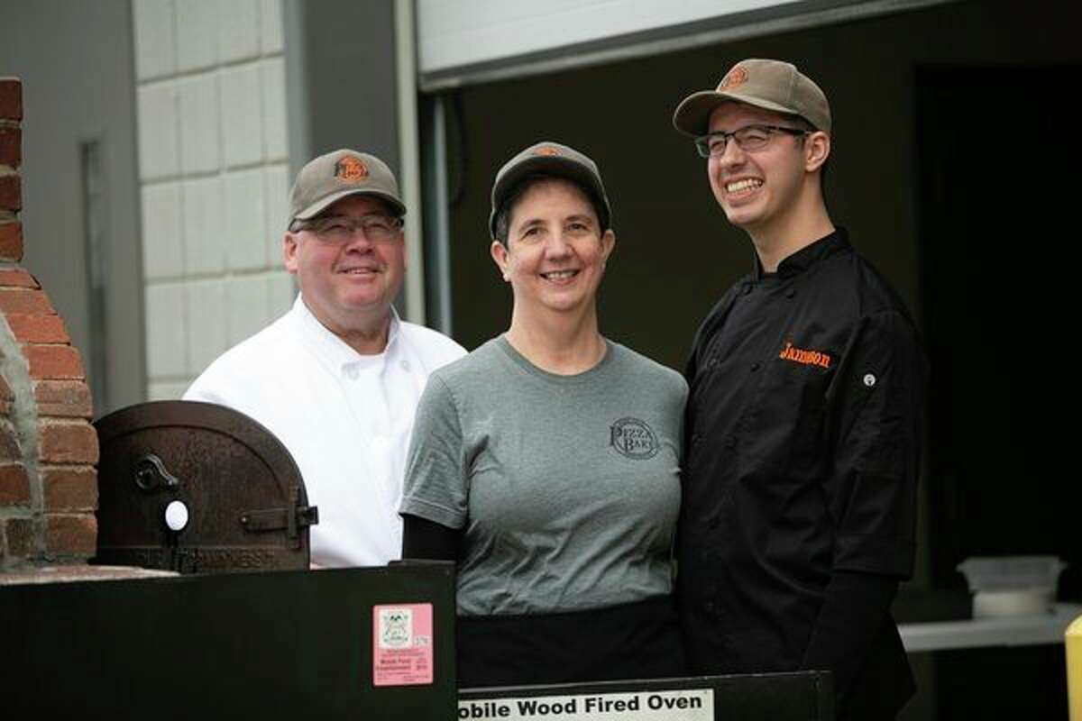 Jim, Janet and Jameson Baker pose for a photo with their wood-fired pizza oven. (Photo provided)