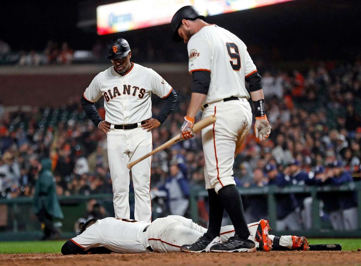San Francisco Giants' Gerardo Parra lies on the ground after being hit by a pitch in 7th inning against San Diego Padres during MLB game at Oracle Park in San Francisco, Calif., on Monday, April 8, 2019.