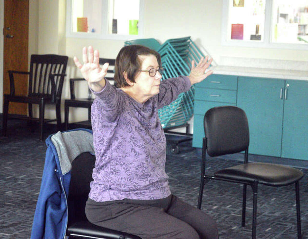 Nancy Kelley of Edwardsville participates in a chair yoga class on Monday afternoon at the Edwardsville Public Library. The class, which meets once a month, is one of many free events for seniors.