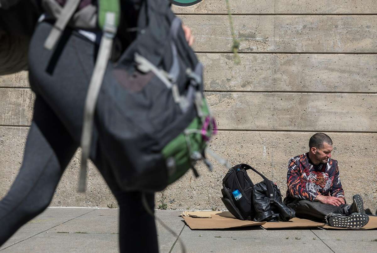 Tyson Feilzer, 40, sits on a cardboard box along Bryant Street near Main Street along the Embarcadero in San Francisco, Calif. Sunday, April 7, 2019.